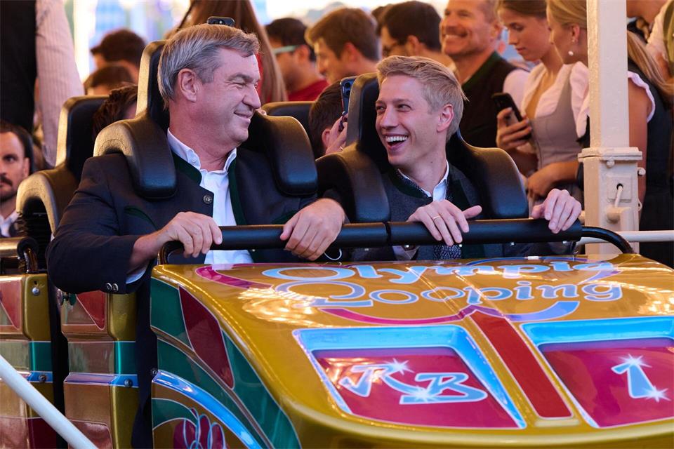 Markus Söder (CSU), Ministerpräsident von Bayern, und Dominik Krause (Bündnis 90/ Die Grünen), Oberbürgermeister von München, fahren anlässlich der Nominierung Münchens als deutscher Olympia-Bewerber auf dem Oktoberfest zusammen mit der Achterbahn „Olympia Looping“. Sven Hoppe/dpa