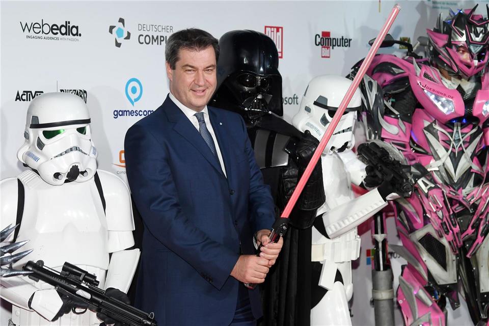 Markus Söder hält ein Laserschwert.Tobias Hase/dpa