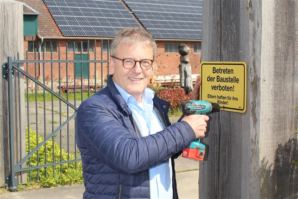 Martin Manns, der Eigentümer der ehemaligen Ziegelei, schraubt das Baustellen-Schild ab.