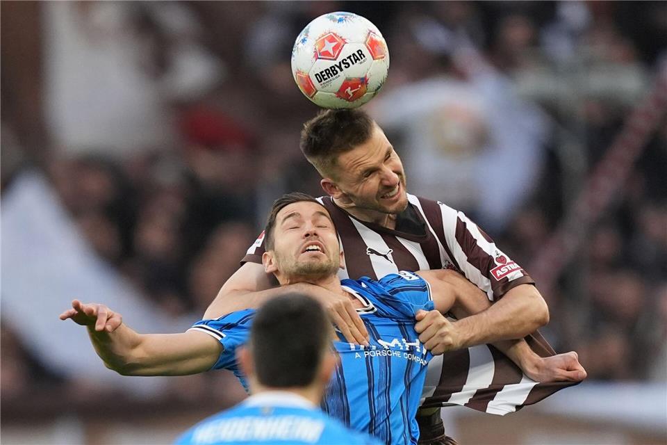Marvin Pieringer verliert zwar das Kopfballduell gegen Karol Mets (r, FC St. Pauli), war aber der beste Heidenheimer.Marcus Brandt/dpa