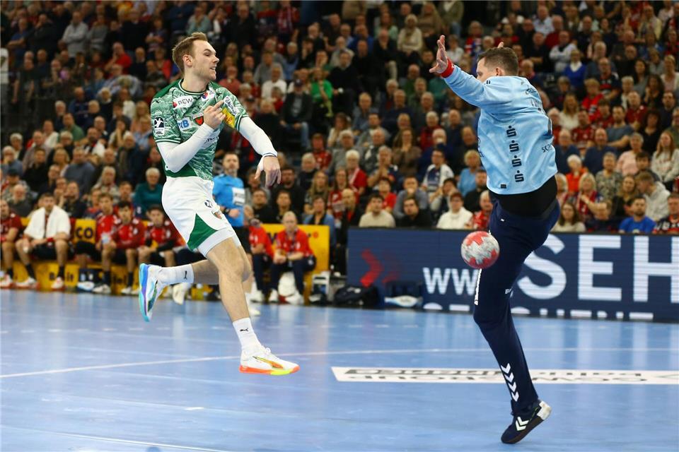 Mathias Gidsel (Füchse Berlin, l) wirft gegen den Flensburger Torwart Kevin Möller.Michael Hundt/dpa