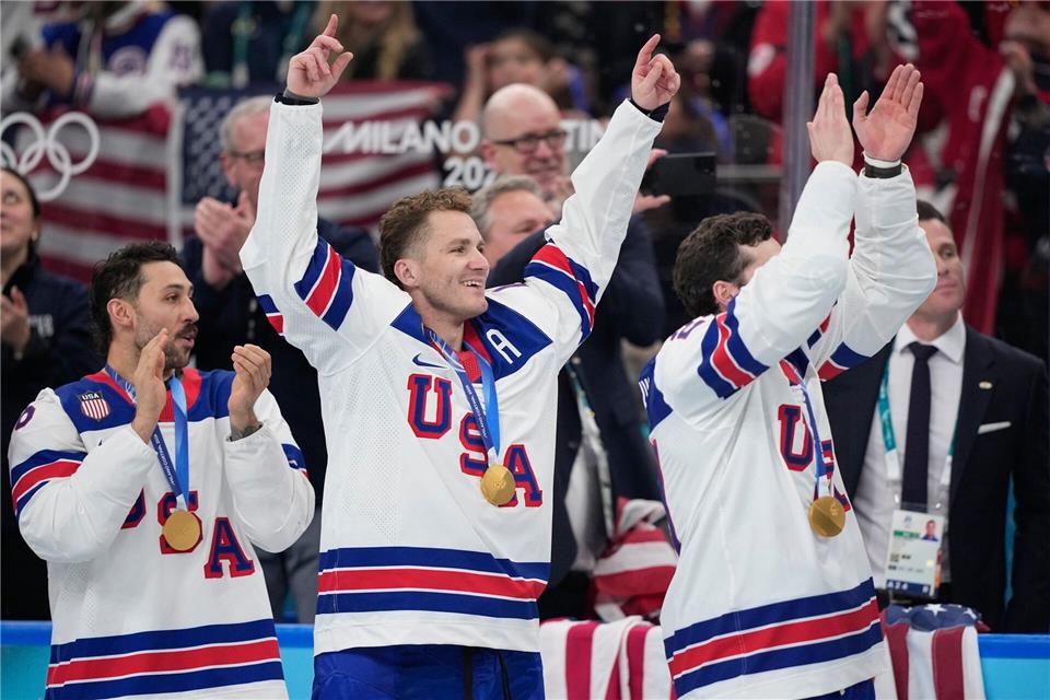 Matthew Tkachuk (Mitte) vom Team USA bejubelt mit seinen Mitspielern die Goldmedaille bei den Olympischen Winterspielen 2026.Petr David Josek/AP/dpa