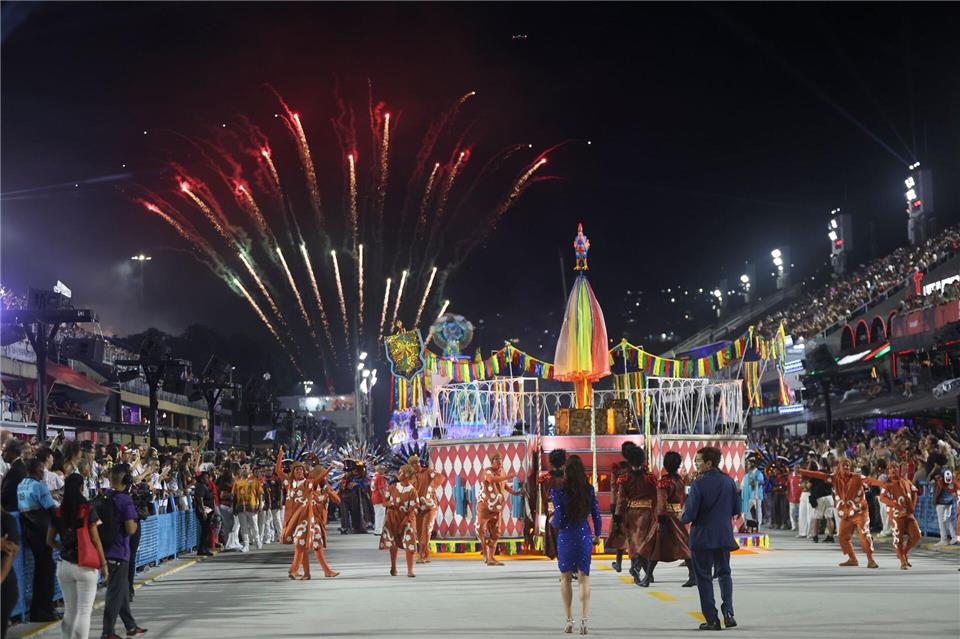 Mehrere Sambaschulen ziehen mit bunten Wagen durch die Straße.Fernando Souza/dpa
