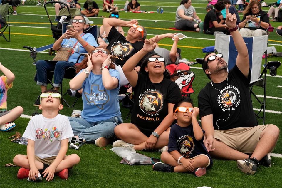 Menschen beobachten 2024, wie der Mond die Sonne während einer totalen Sonnenfinsternis teilweise verdeckt, gesehen von Eagle Pass, Texas.Eric Gay/AP/dpa