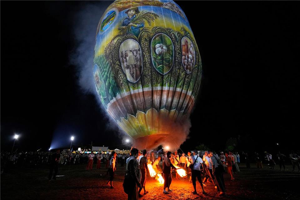 Menschen bereiten sich auf den Start eines Heißluftballons während eines Wettbewerbs anlässlich des Tazaungdaing-Fests in Naypyitaw in Myanmar vor.Aung Shine Oo/AP/dpa