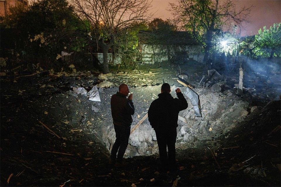 Menschen betrachten einen Krater.Evgeniy Maloletka/AP/dpa