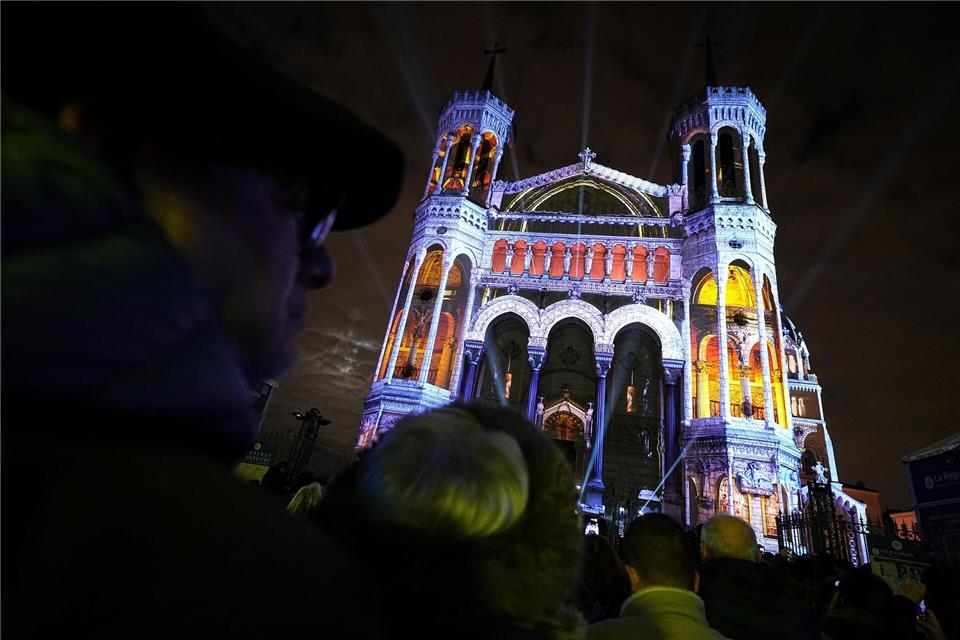 Menschen betrachten in Lyon die Basilika Notre-Dame de Fourviere.Laurent Cipriani/AP/dpa