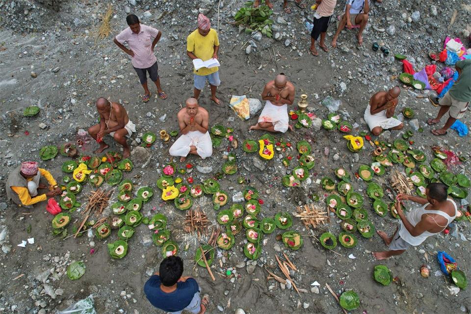 Menschen, deren Angehörige nach den Sturzfluten weiterhin vermisst werden, vollziehen am Ufer des angeschwollenen Trishuli-Flusses im nepalesischen Distrikt Nuwakot Rituale im Anschluss an symbolische Bestattungszeremonien.Rajesh Kumar Singh/AP/dpa