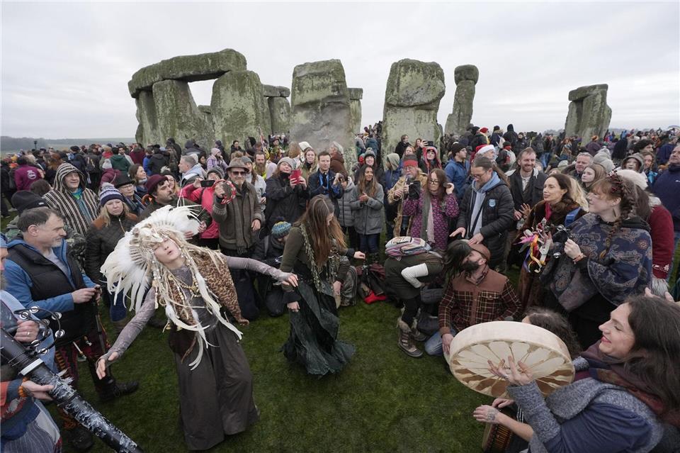 Menschen feiern die Wintersonnenwende am prähistorischen Monument von Stonehenge.Andrew Matthews/PA Wire/dpa