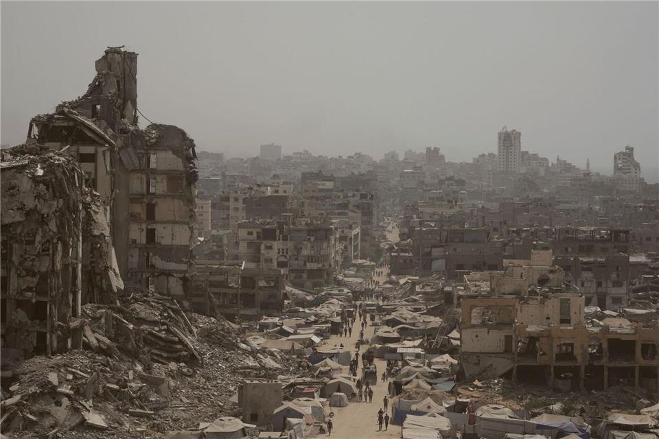 Menschen gehen auf zerstörter Straße im Gazastreifen. (Archivbild)Jehad Alshrafi/AP/dpa