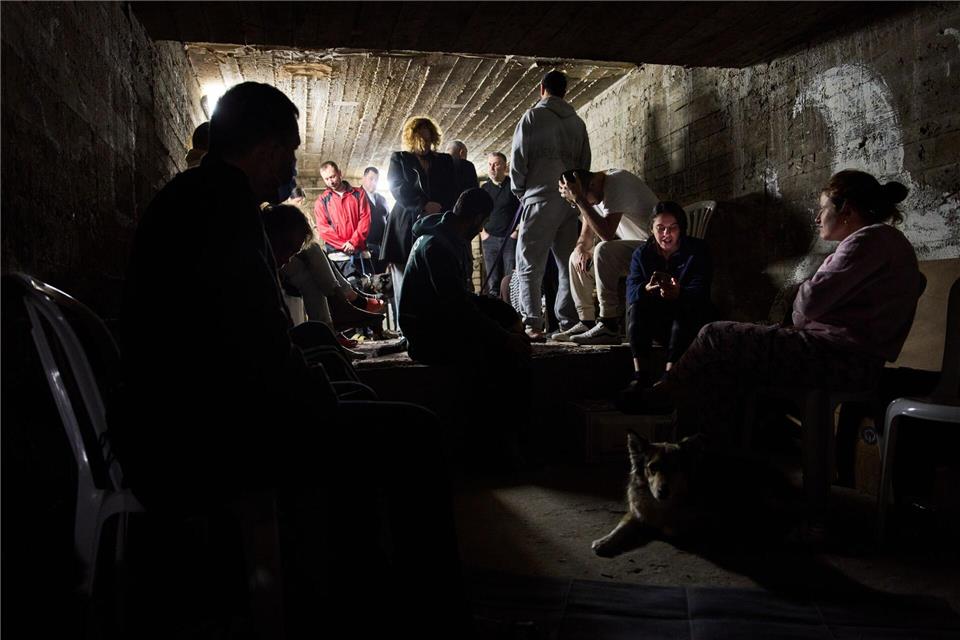 Menschen gehen in Israel in einem Luftschutzkeller in Deckung.Oded Balilty/AP/dpa