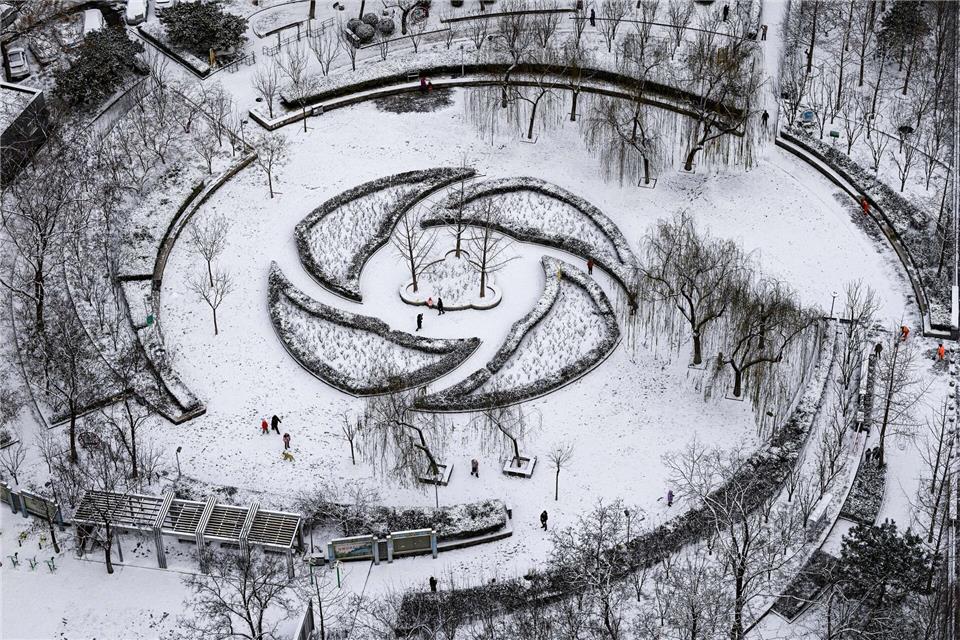 Menschen haben Spaß im Schnee in einem Park in Peking.Chen Yehua/XinHua/dpa