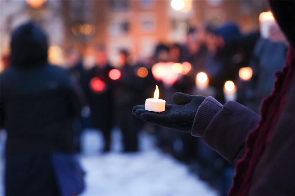Menschen halten Lichter am Joseph-Carlebach-Platz.Christian Charisius/dpa