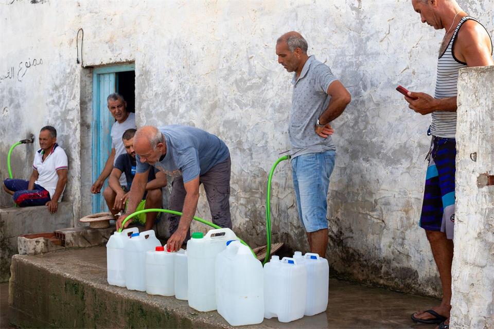 Menschen in Tunesien befüllen Wasserbehälter mit Trinkwasser.Anis Mili/AP/dpa