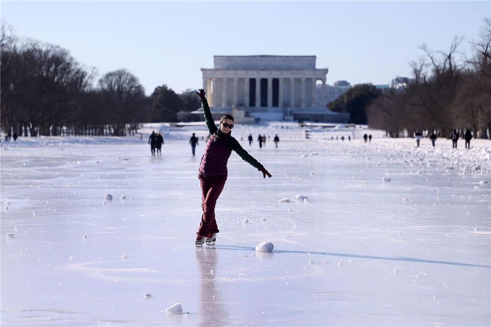 Menschen laufen Schlittschuh auf dem zugefrorenen Wasserbecken vor dem Lincoln Memorial.Gent Shkullaku/ZUMA Press Wire/dpa