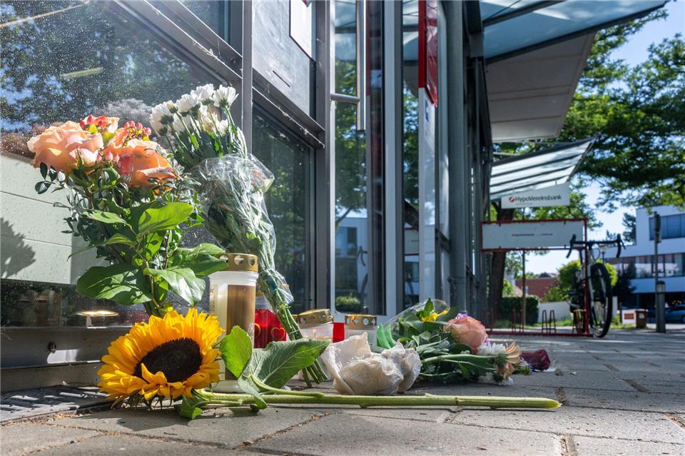 Menschen legten nach dem tödlichen Angriff Blumen und Kerzen vor der Filiale ab.Armin Weigel/dpa