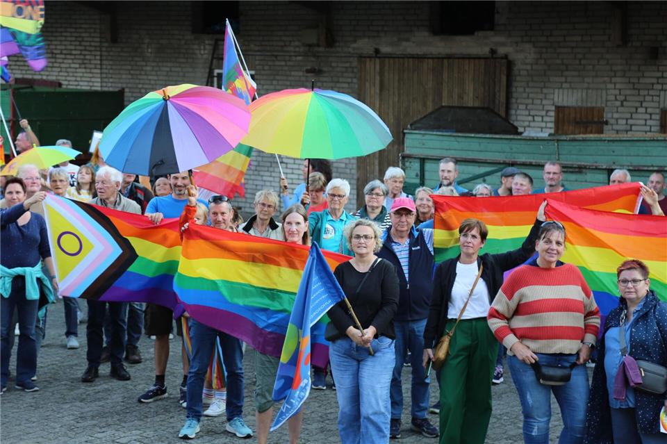 Menschen mit Regenbogenflaggen und -schirmen beteiligten sich an einer Kundgebung.Benjamin Müller/dpa