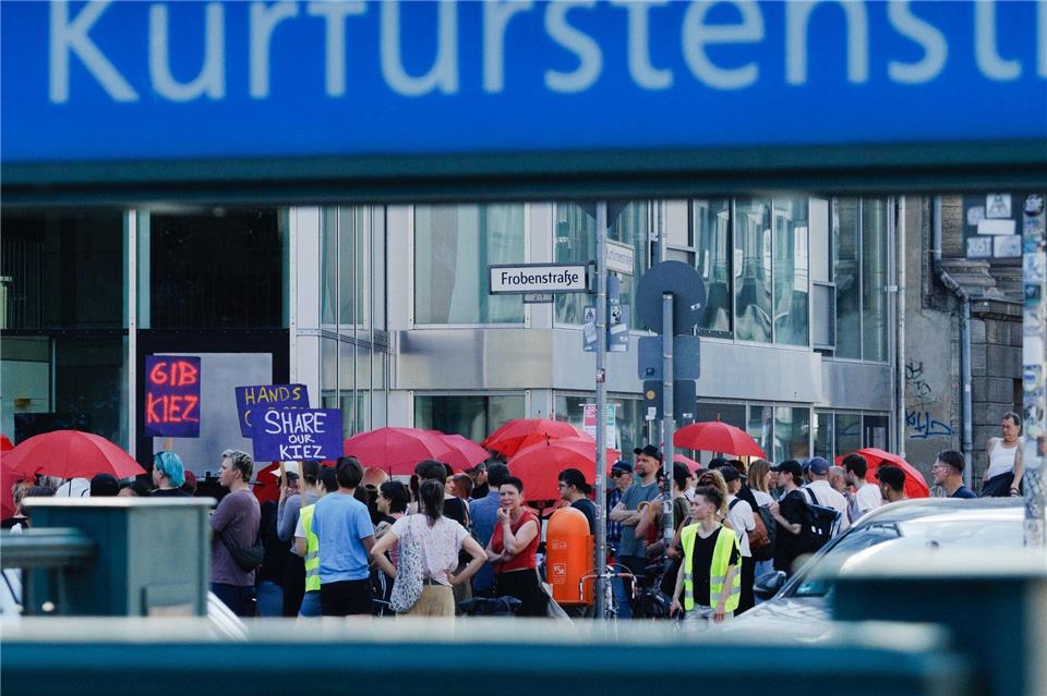 Menschen mit roten Schirmen demonstrieren gegen ein Verbot der Straßenprostitution.Carsten Koall/dpa