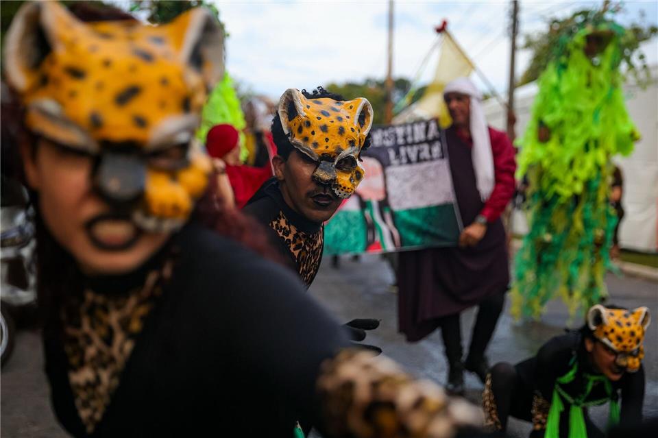 Menschen nehmen am Ufer des Guamá-Flusses in Brasilien an der Eröffnung des People’s Summit, einer Initiative von mehr als tausend sozialen Bewegungen und Basisorganisationen aus der ganzen Welt, die sich für Klimagerechtigkeit einsetzen und die „Untätigkeit der Länder des globalen Nordens“ anprangern, teil.Allison Sales/dpa