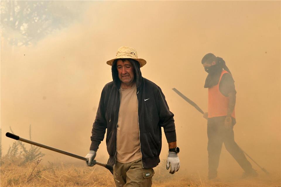 Menschen reagieren bei der Bekämpfung eines Waldbrandes in Veiga das Meas im Nordwesten Spaniens.Lalo R. Villar/AP/dpa
