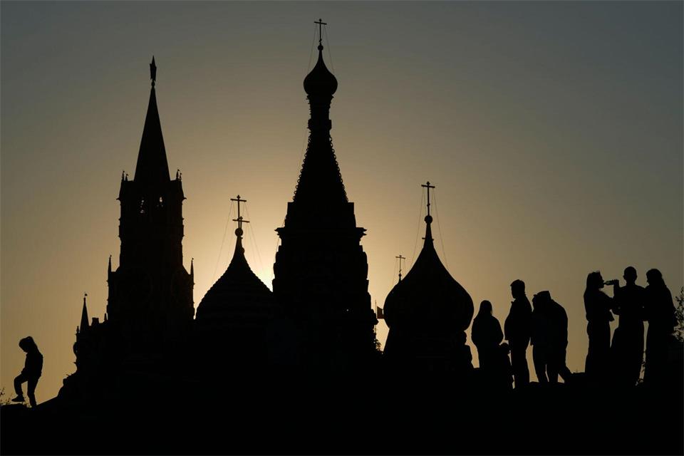 Menschen spazieren bei Sonnenuntergang im Zaryadye-Park in Moskau vor dem Hintergrund des Spasskaja-Turms des Kremls und der Basilius-Kathedrale.Pavel Bednyakov/AP/dpa