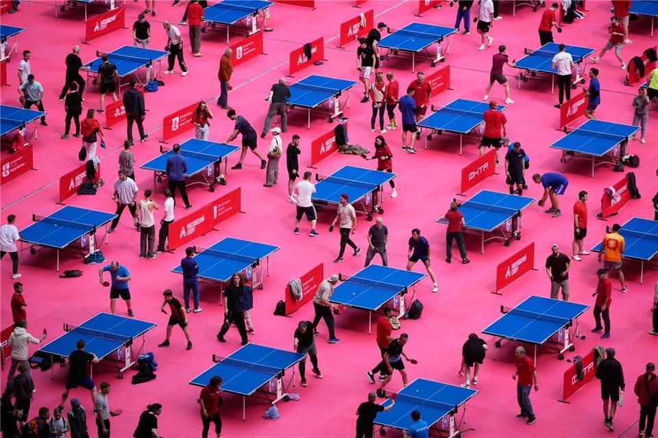 Menschen spielen Tischtennis auf dem Spielfeld des Luschniki-Stadions in Moskau während des Tischtennisfestivals.Pavel Bednyakov/AP/dpa