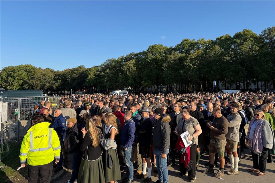 Menschen stehen am südlichen Eingang der Wiesn.Christof Rührmair/dpa