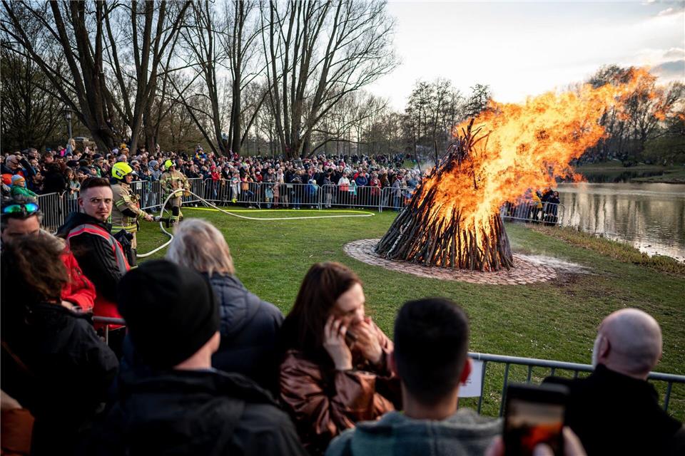 Menschen stehen um das Osterfeuer im Britzer Garten in Berlin. (Archivbild)Fabian Sommer/dpa