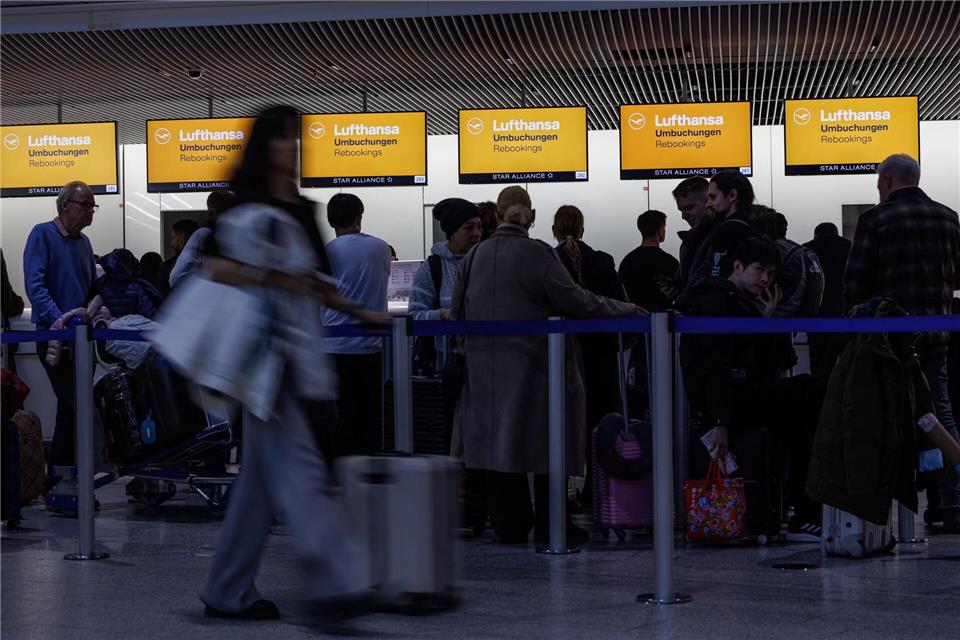 Menschen stehen vor einem Service Schalter der Lufthansa am Frankfurter Flughafen. Hannes P. Albert/dpa