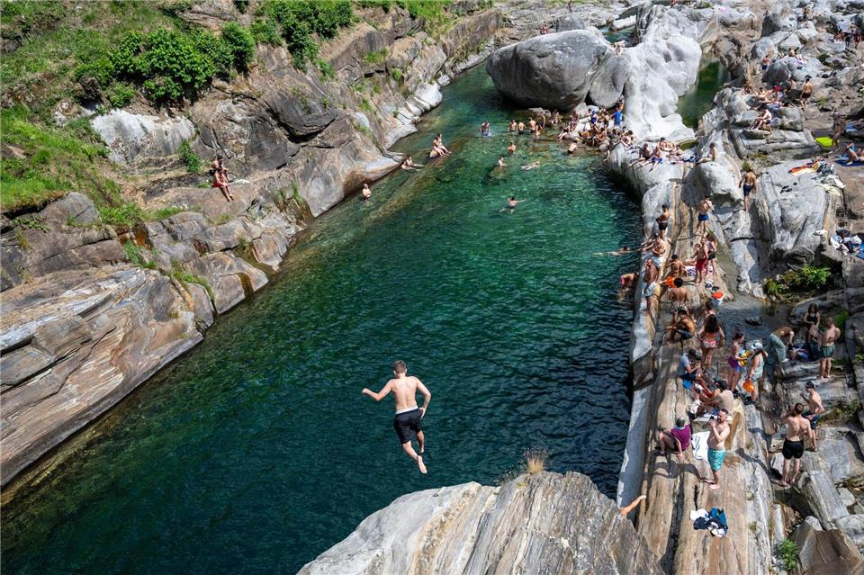 Menschen suchen Abkühlung im Wasser des Flusses Verzasca in der Schweiz.Samuel Golay/KEYSTONE/dpa