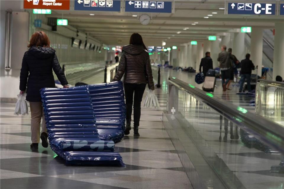 Menschen tragen nach möglichen Drohnensichtungen am Flughafen München Luftmatratzen. Enrique Kaczor/onw-images/dpa