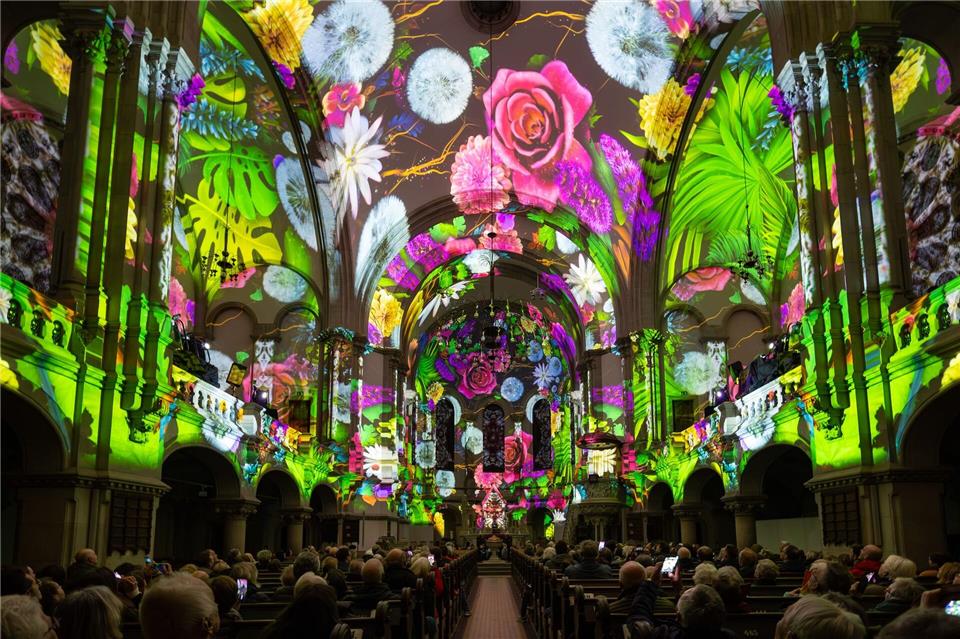 Menschen verfolgen in der Dresdner Martin-Luther-Kirche eine Lichtshow.Jürgen Lösel/dpa/ZB