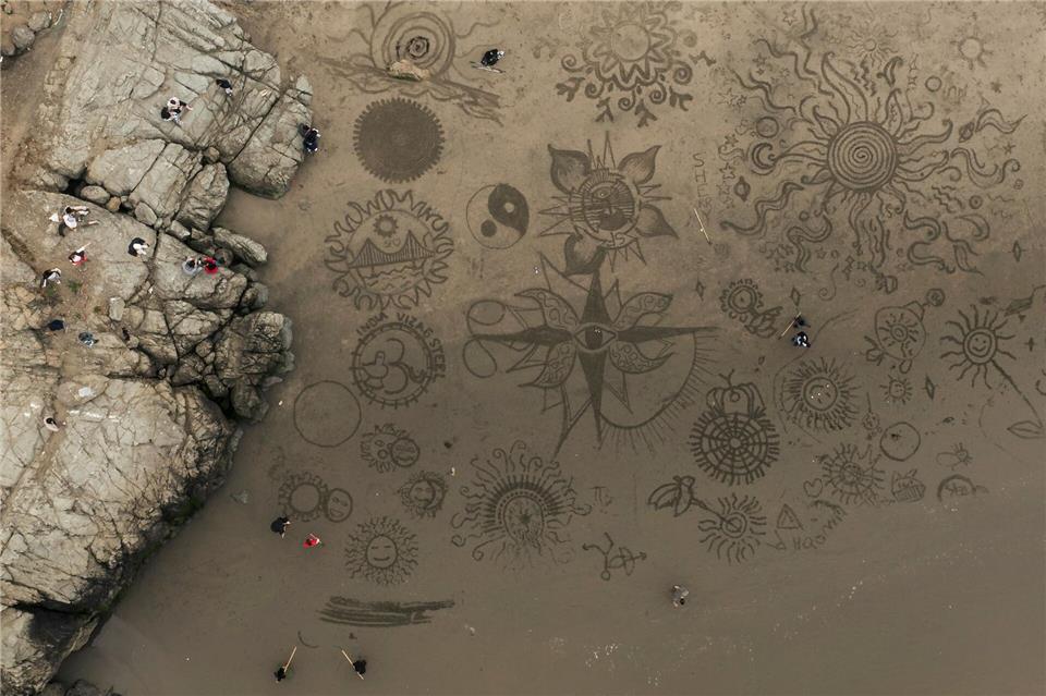 Menschen versammeln sich am Ocean Beach in San Francisco, um bei einer von Künstler Andres Amador organisierten Veranstaltung Kunstwerke im Sand zu gestalten.Stephen Lam/San Francisco Chronicle/AP/dpa