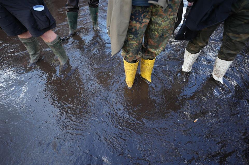 Metalfans stehen beim Wacken Open Air knöcheltief im Schlamm.Marcus Brandt/dpa