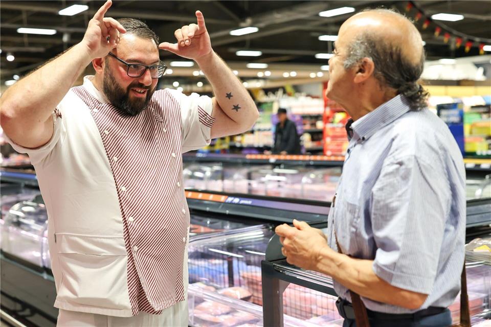 Metzger Yevgeniy Klibanov zeigt die Gebärde für „Rind“. Daniel Löb/dpa