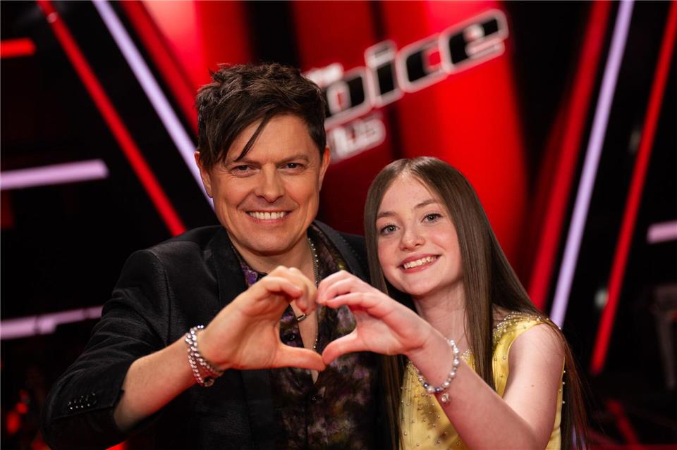 Michael Patrick Kelly steht beim Finale der Musikshow „The Voice Kids“ neben Kandidatin Katelyn auf der Bühne.Christophe Gateau/dpa