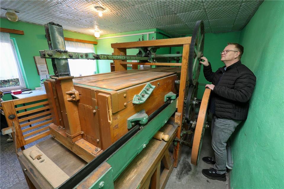 Michael Richter prüft nach dem Winter Zahnräder und Riemenantrieb der Kaltmangel in Heinrichsort. Jan Woitas/dpa
