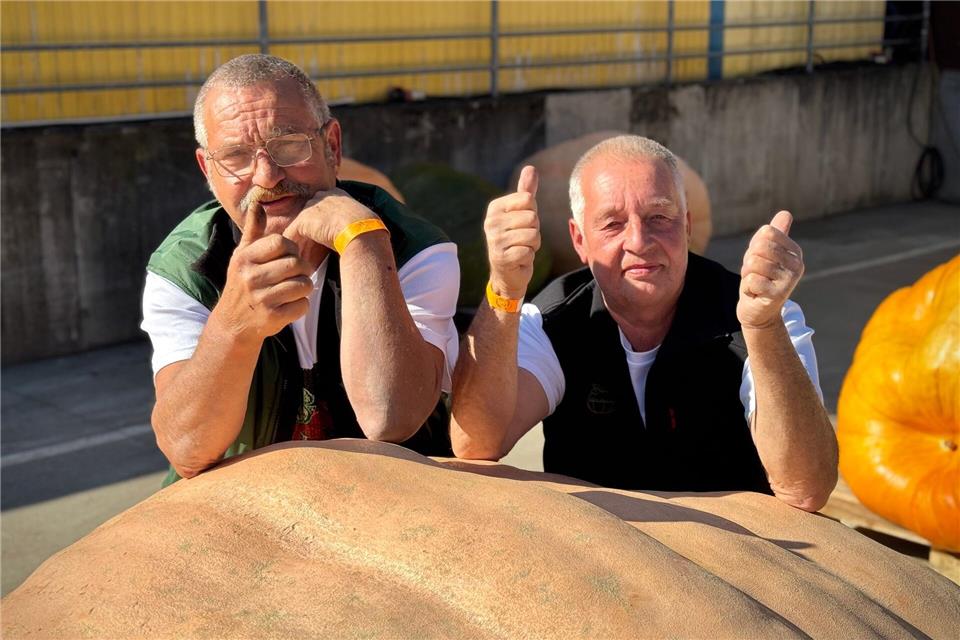 Michael Schade und Bernd Paul aus Beelitz sind die Sieger der diesjährigen Kürbis-Wiegemeisterschaft in Brandenburg und knackten mit ihrem orangefarbenen Riesen die 1.000-Kilo-Marke.Lukas Kupke/Spargelhof Klaistow/dpa