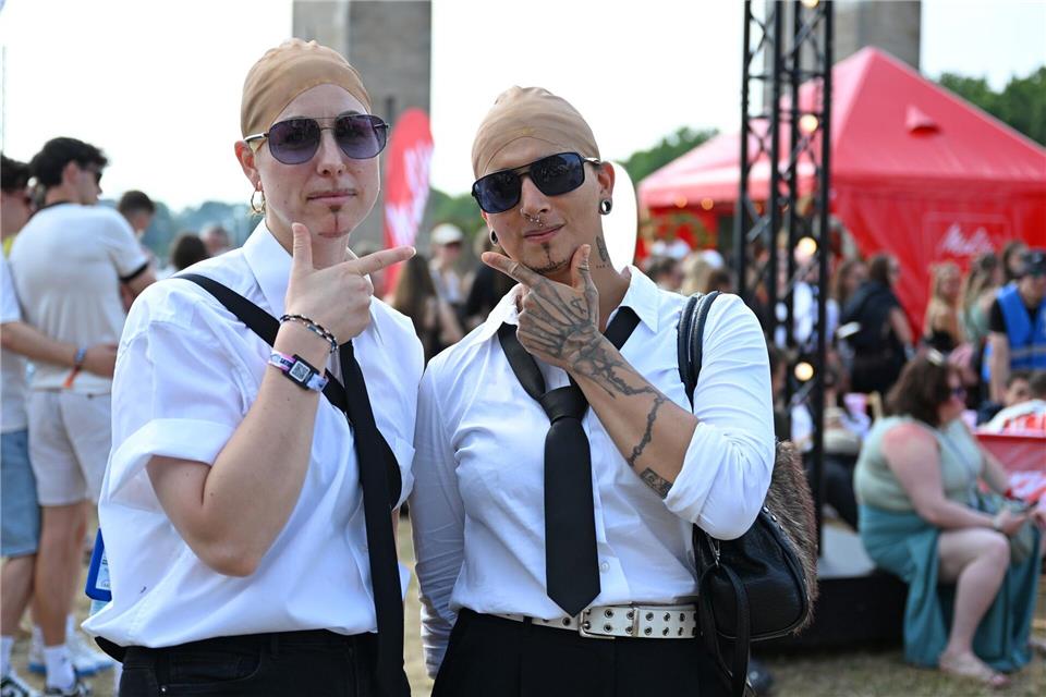 Mila (l) hatte wie Tausende andere Fans den klassischen Dresscode für den Pitbull-Auftritt gewählt.Elisa Schu/dpa
