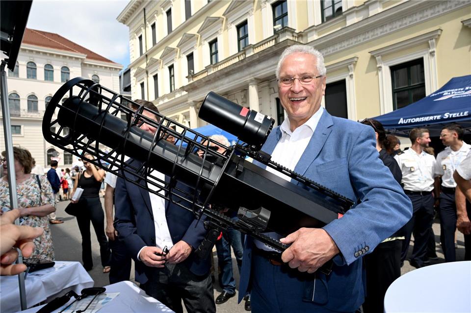 Minister Herrmann zeigt ein Gerät zur Drohnenabwehr. Felix Hörhager/dpa
