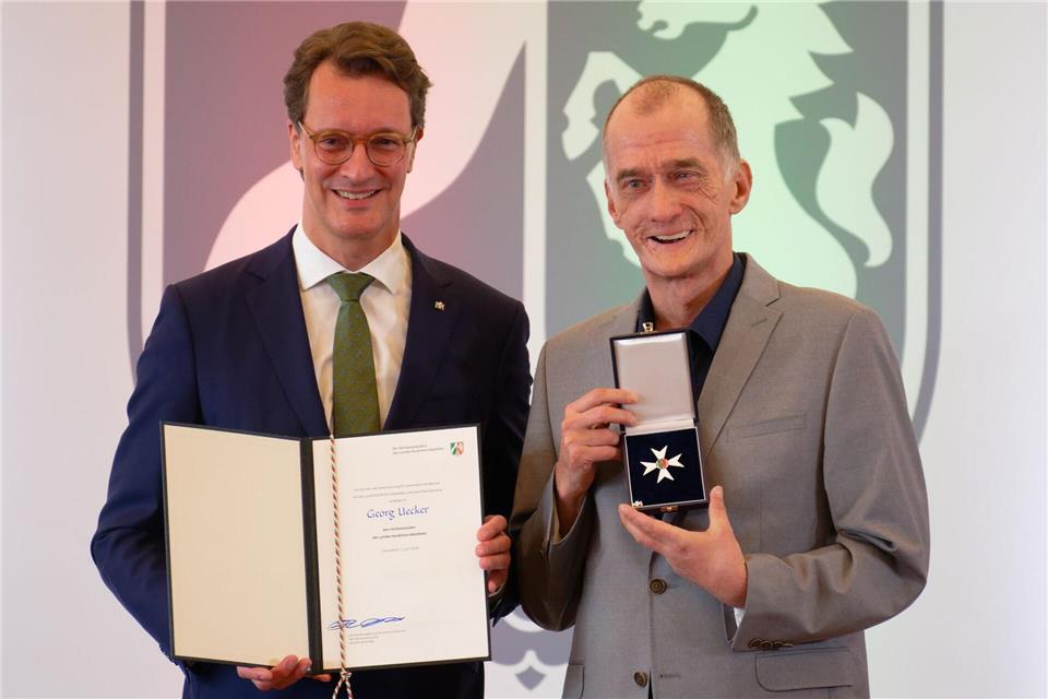 Ministerpräsident Hendrik Wüst (CDU, l) verleiht den Verdienstorden des Landes Nordrhein-Westfalen an den Schauspieler Georg Uecker.Henning Kaiser/dpa
