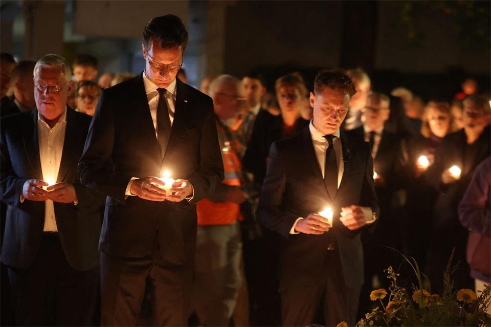 Ministerpräsident Hendrik Wüst und Oberbürgermeister Daniel halten Kerzen in der Hand. Christoph Reichwein/dpa