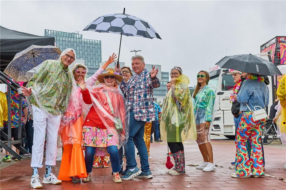 Mit Capes und Regenschirmen schützen sich die Schlagerfans beim Schlagermove vor dem Hamburger Schietwetter. Georg Wendt/dpa