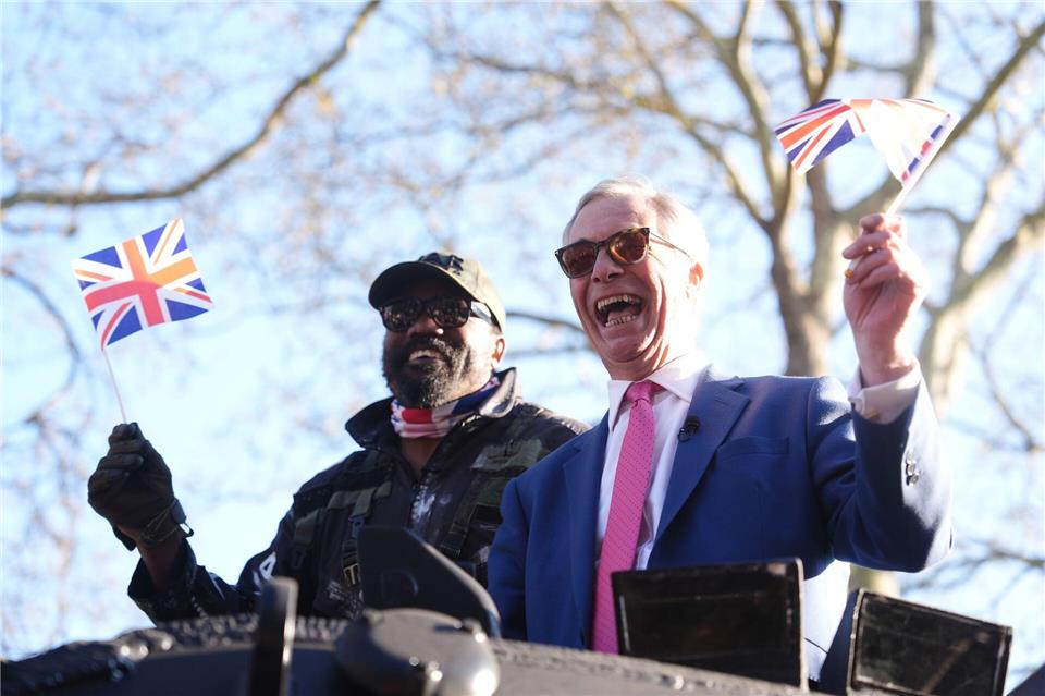 Mit Fähnchen auf dem Panzer: Boxer Derek Chisora (l) und Politiker Nigel Farage.Adam Davy/PA Wire/dpa