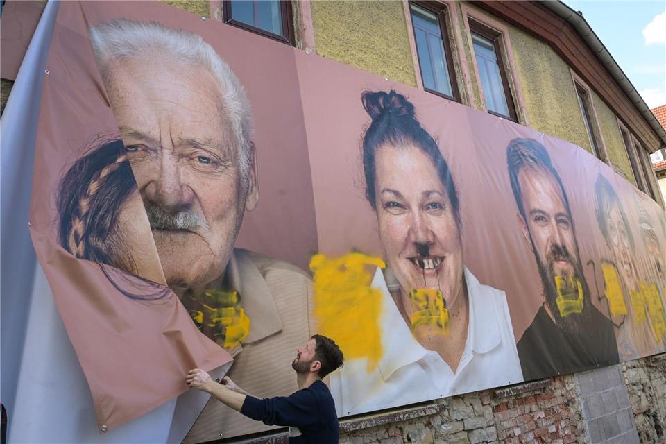 Mit Hakenkreuzen und rechten Parolen sind in Allstedt (Mansfeld-Südharz) diverse Häuserfassaden beschmiert worden - auch ein großformatiges Porträtbanner einer Kunstausstellung ist betroffen.Heiko Rebsch/dpa