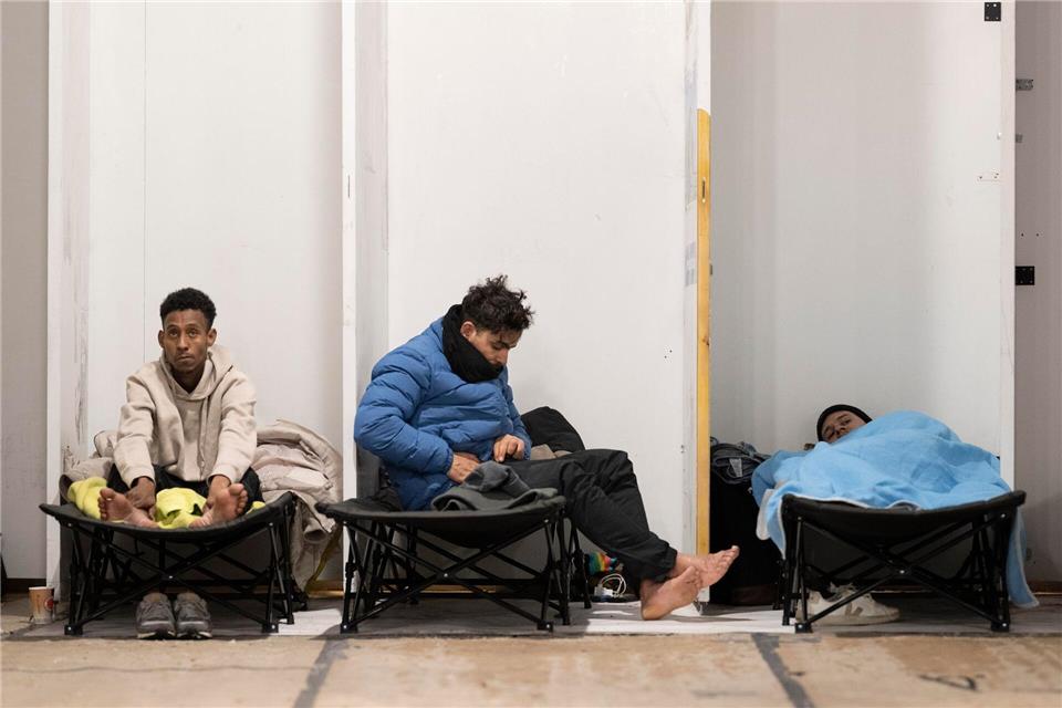 Mit Platten als Sichtschutz abgetrennt stehen die Feldbetten im Kirchenraum nebeneinander. Boris Roessler/dpa