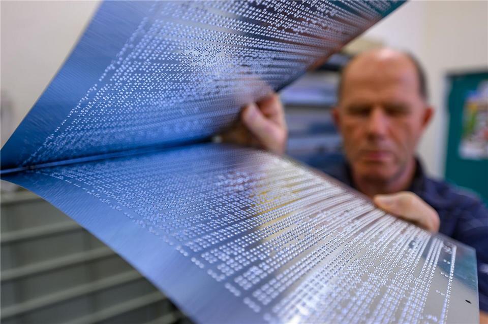 200 Jahre Braille - KI macht Punktschrift noch vielseitiger  Mit Punzierplatten wird die Brailleschrift in der Druckmaschine ins Papier geprägt.Hendrik Schmidt/dpa