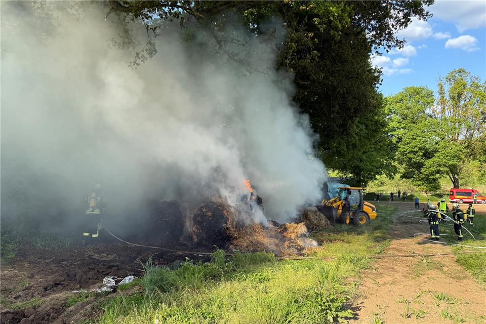 Mit Radladern wurden die qualmenden Ballen auseinandergezogen.