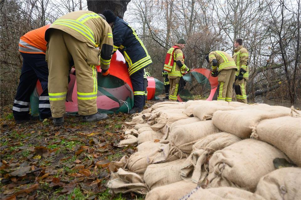 Mit Sandsäcken schützten Einsatzkräfte an Heiligabend 2023 bedrohte Häuser vor dem steigenden Wasser. (Archivbild)Julian Stratenschulte/dpa