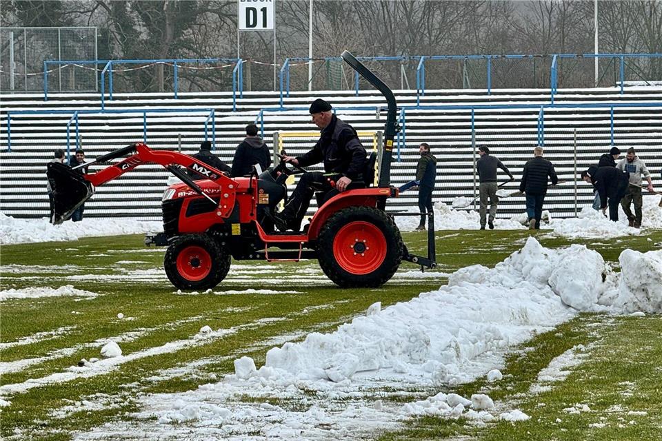 Mit Schaufeln und Schneeschiebern im Einsatz: Vorbereitung auf das Rugby-Länderspiel in Dessau-RoßlauThomas Schulz/dpa